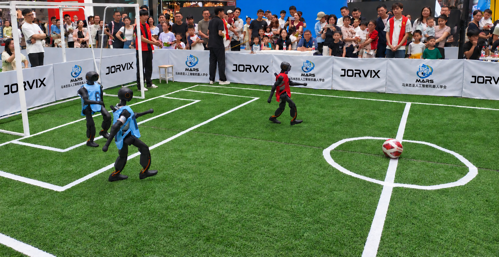 Blue and red humanoid robots playing football at a Jorvix event
